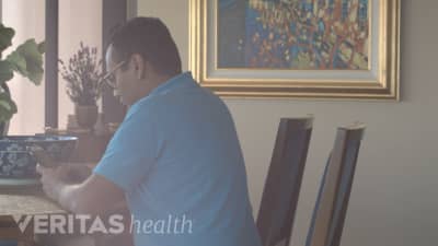 Man sitting at a desk looking down at his phone