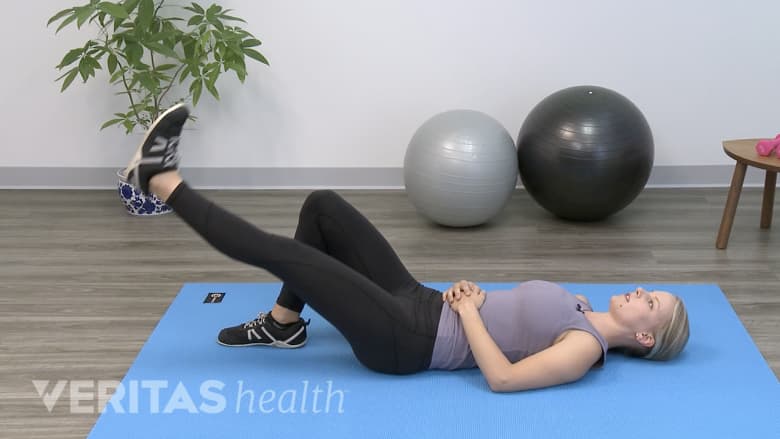 Therapist showing leg raise exercise.