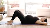 Pregnant woman lying on exercise mat in for the pelvic tilt exercise