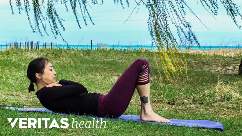 Mujer al aire libre realizando un abdominal curl up