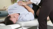 Chiropractor manipulating a patient's lower back