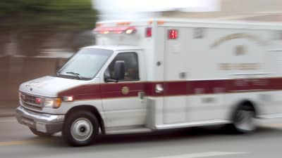 Ambulance driving fast down a road