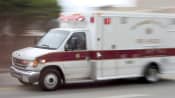 Ambulance driving fast down a road