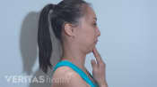 Side profile of woman performing the chin tuck exercise