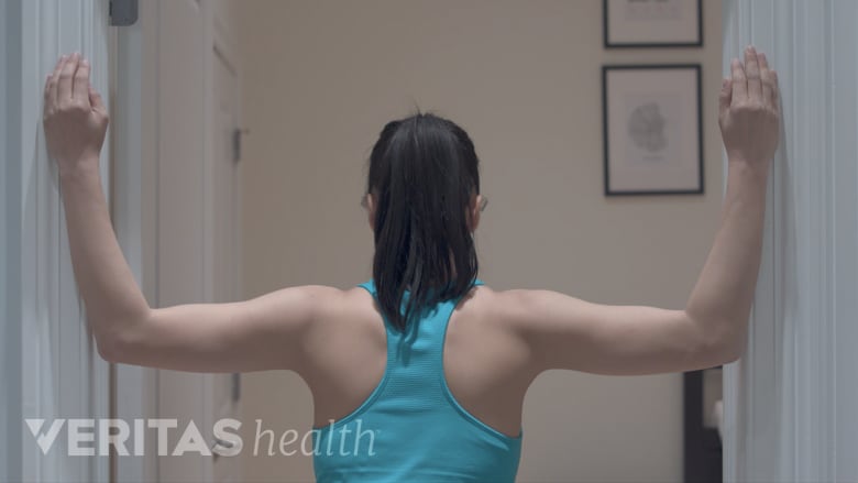 Woman doing the corner stretch exercise for upper and middle back pain