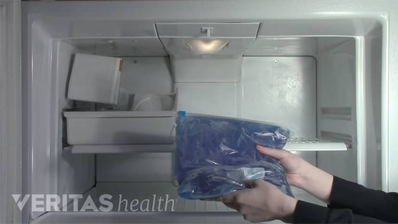 Woman grabbing ice pack out of freezer