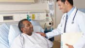 Doctor speaking with a patient in a hospital bed.