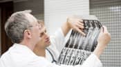 Two male physicians reviewing a series of x-rays