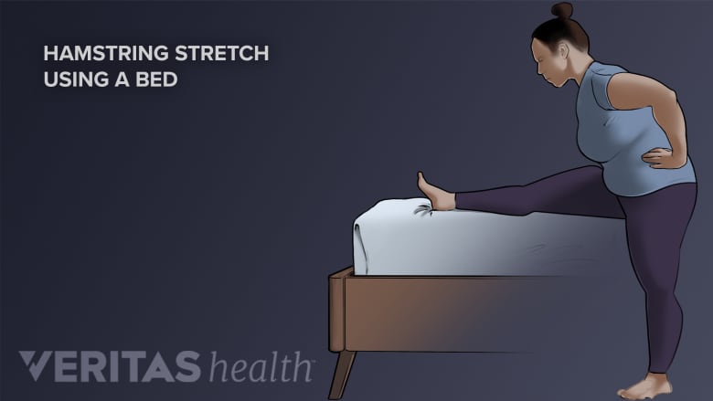 Person doing a hamstring stretch on the bed.
