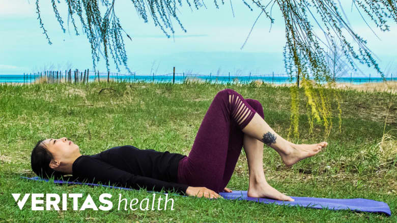 Woman performing hook lying march outdoors