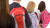 Four teenagers carrying backpacks
