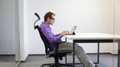 Man sitting at a desk with incorrect posture