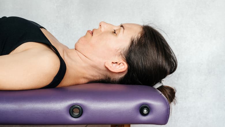 McKenzie method neck exercise head retraction in lying.