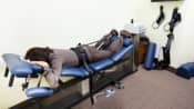 Woman lying prone on a spinal decompression chair