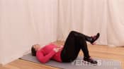 Woman lying prone on yoga mat doing a piriformis muscle stretch.
