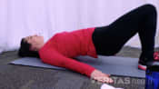 Profile of woman performing the bridging stretch.