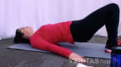 Profile of woman performing the bridging stretch.