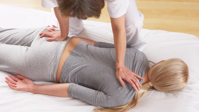 Client lying prone receiving a massage.