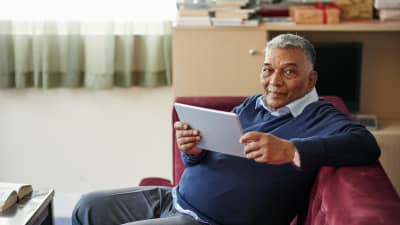 Man recovering at home while on his tablet.