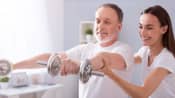 Therapist assisting patient with shoulder exercises using dumbbells.