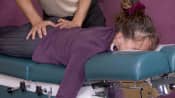 Chiropractic adjustment being applied to the lower back.