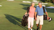 Couple walking happily on the golf course.