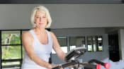 Elderly woman on stationary bicycle