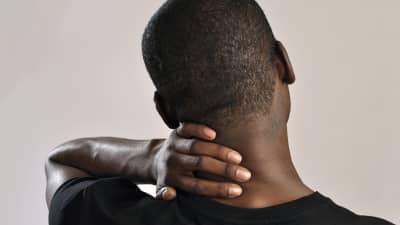 Man holding their neck in pain