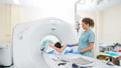 Technician assisting a patient through a CT scan