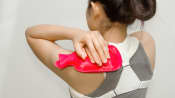 Woman applying a hot pack to her shoulder