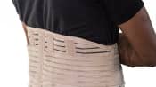 Man's torso with a lower back brace over his shirt