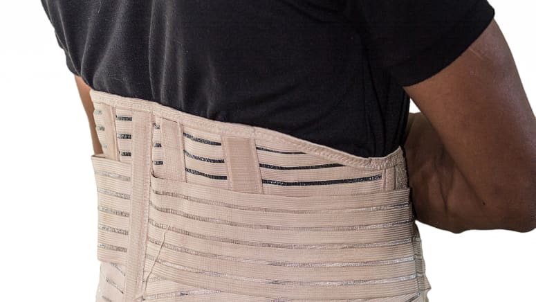 Man's torso with a lower back brace over his shirt