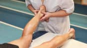 Therapist doing myofascial release therapy on a man's ankle