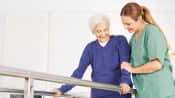 Physical therapist helping a patient walk