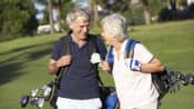 Couple walking happily on the golf course.