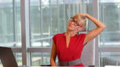 Woman performing a neck exercise at her desk