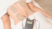 Tens unit being applied to the lower back.