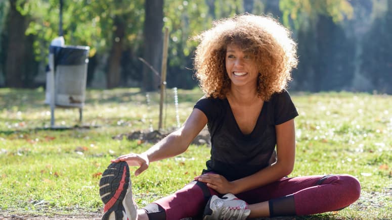 Woman doing a forward fold at the park