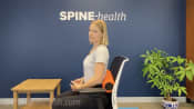 Woman sitting with a foam roller for lumbar support