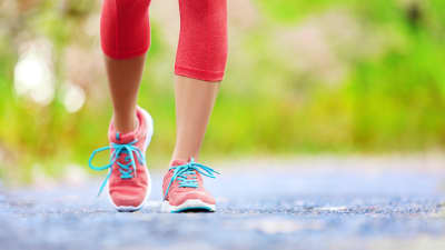 Women's feet walking with sneakers.