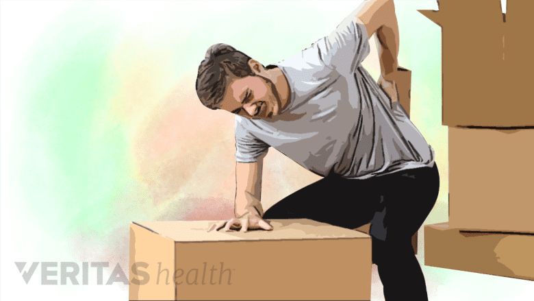 A man trying to lift heavy object is in pain.