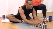 Woman doing a wall hamstring stretch.