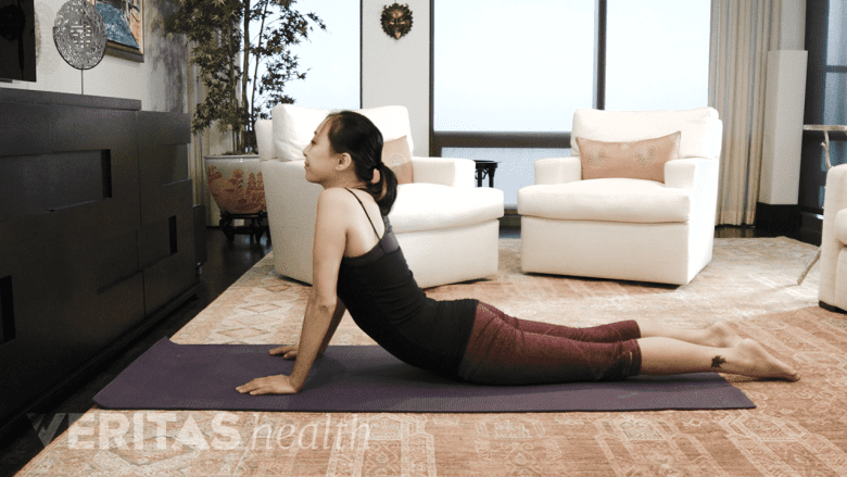 Mujer haciendo el ejercicio avanzado de presión para aliviar el dolor ciático.